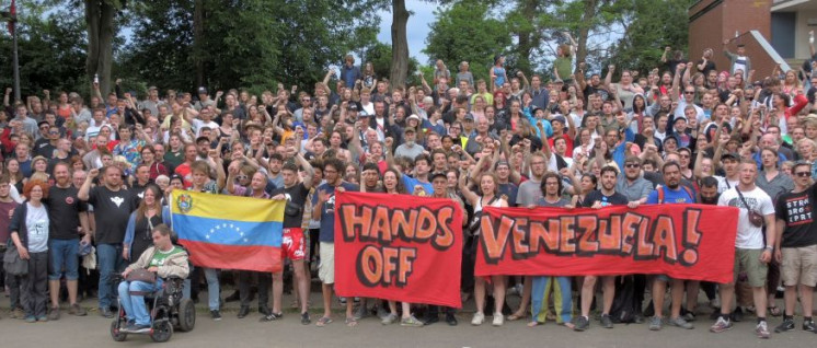 Fäuste ballen, Hände weg: Nach der Rede Carolus Wimmers, Internationaler Sekretär der Kommunistischen Partei Venezuelas, zeigten die Teilnehmer mit diesem Foto ihre Solidarität mit dem venezolanischen Volk, das sich gegen Angriffe aus den USA verteidigt.  (Foto: Tom Brenner)