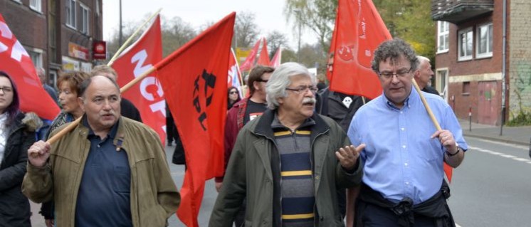 Patrik Köbele (ganz rechts) im Gespräch mit Ali Ruckert (KPL) auf der Demo vor der Vier-Parteien-Konferenz in Münster 2017 (Foto: Tom Brenner)